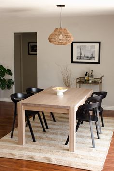 a dining room table with four chairs and a bowl on top of it in front of a doorway