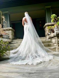 a woman in a wedding dress standing on some steps