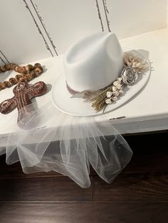 a white hat sitting on top of a table next to beads and other items in front of it