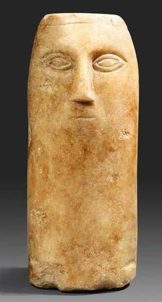 a stone head with two eyes on it