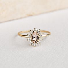 an engagement ring with a pink diamond surrounded by small white and brown diamonds on it