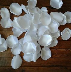 white paper petals scattered on top of a wooden table