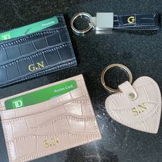 two credit cards, a card holder and a keychain on a black table