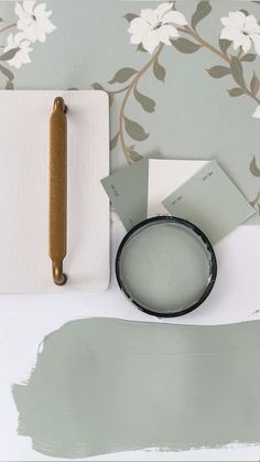 some paint samples and a brush sitting on a table next to a wallpaper roller