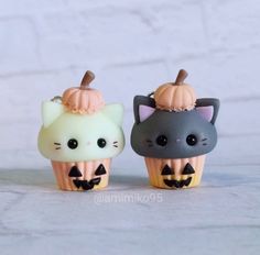 two small cupcakes decorated like cats with pumpkins on top and the words shop is now live above them