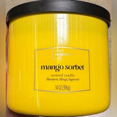 a close up of a person holding a jar of mango sorbet