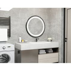 a washer and dryer in a bathroom next to a sink with a mirror above it