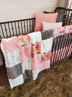 a baby crib with pink and black bedding