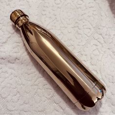 a silver bottle sitting on top of a white towel