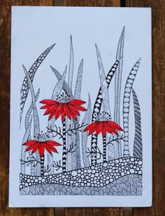 a card with red flowers on it sitting on top of a wooden table