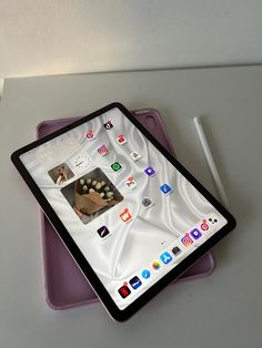 an ipad sitting on top of a table next to a white pen and paper holder