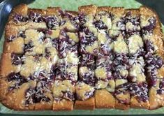 a pan filled with lots of food on top of a green tablecloth covered counter