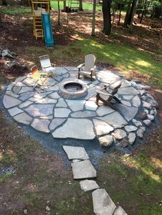 an outdoor fire pit with chairs around it