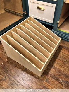 an empty drawer sitting on top of a wooden floor