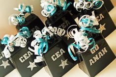 small black and white gift bags with blue ribbons on them are decorated with stars, letters and numbers