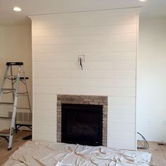 a living room with a fire place and ladder