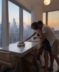 a man and woman standing in front of a table with food on top of it