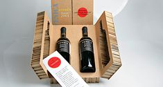 two bottles of wine sitting in a cardboard box next to an envelope and paper tag