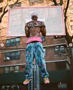 a man standing on top of a basketball hoop