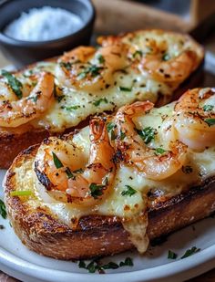 two pieces of bread topped with shrimp and cheese