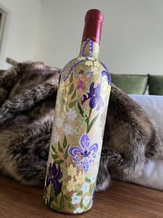 a wine bottle sitting on top of a wooden table next to a fur covered couch