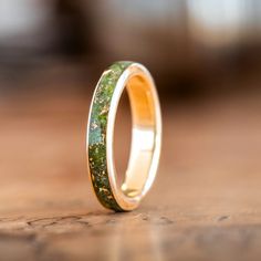 Presenting The Erinn - a beautiful gold women's wedding band made of 100% recycled gold and a captivating center inlay of green imperial diopside and gold flakes. Inspired by the emerald landscapes of Ireland, this ring is perfect for the bride who wants a piece of jewelry that is both timeless and unique.The Erinn Ring Features: SCS certified 100% recycled gold ring base Available in: 10K, 14K or 18K yellow gold, rose gold or white gold Natural imperial diopside ring inlay with gold flakes Hand Recycled Gold Ring, 10k Gold Ring, Gold And Green, Gold Mining, Gold Flakes, Womens Wedding Bands, 14k Gold Ring, Recycled Gold, Gold Wedding Band