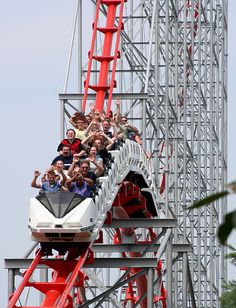 people are riding the roller coaster at an amusement park