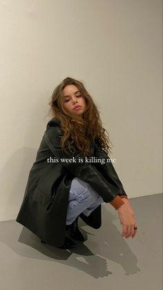 a woman sitting on the ground in front of a white wall with an instagram message