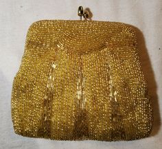 VINTAGE SMALL GOLD COLORED BEADED PURSE / HANDBAG WITH HANDLE STRAP ATTACHMENT AND CLASP TOP This is a small vintage gold colored purse/handbag with strap and clasp attachment on top. It has a nice intricate design and is in wonderful condition for its age. Please see pictures for design and condition detail. Measures 5.5" wide at widest bottom part by 5.5" tall to top of clasp. Wonderful vintage handbag with gold beaded design would be a great piece for your collection. Don't miss it. Purse Trends, Vintage Handbag, Beaded Handbag, Native American Beading, Vintage Purses, Beaded Purses, Vintage Purse, Purse Patterns, Bag Trends