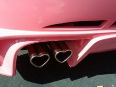 two heart shaped exhaust pipes in the back of a pink car