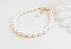 "A classic real freshwater pearl bracelet for newborn, infant, baby, child, little girl, tween or teen. This keepsake bracelet is created with Grade-A 5.5mm round freshwater pearls and a 14K gold-filled oval lobster clasp with a 1/2\" \"Grow with Me\" extender chain. Arrives packaged in my signature high-quality reusable canvas gift bag. Beautiful and ready for gift giving. S I Z I N G . G U I D E The bracelet should be 3/4\" larger than her snug wrist measurement. If you are unable to measure, Elegant Pearl Jewelry For Baptism, Elegant Pearl White Jewelry For Baptism, Classic White Pearl Bracelet For Mother's Day, Elegant Adjustable Pearl Bracelet For Baptism, Elegant Pearl White Jewelry For First Communion, White Hypoallergenic Pearl Bracelet For First Communion, Classic Adjustable Jewelry For First Communion, Hypoallergenic White Pearl Bracelet For First Communion, Classic Adjustable Hypoallergenic Pearl Bracelet