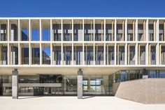 the building has many windows and balconies on each floor, along with concrete pillars