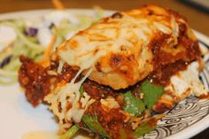 a close up of a plate of food with lasagna and salad on the side