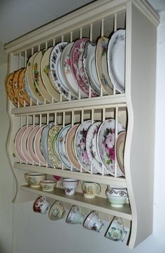 a wall mounted china cabinet filled with lots of plates