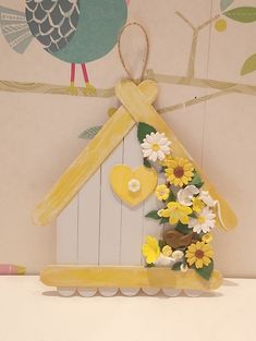 a bird house made out of popsicle sticks and flowers