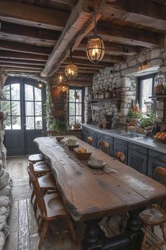 an old rustic kitchen with stone walls and wood flooring, large wooden table surrounded by chairs