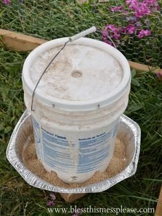 a bucket filled with sand sitting in the grass