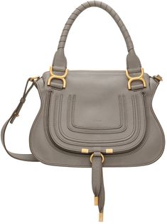 Grained calfskin shoulder bag in gray. · Twin rolled carry handles · Detachable and adjustable shoulder strap · Concealed patch pocket and logo embossed at face · Foldover flap with pull-through fastening at face · Zip closure · Zip pocket at interior · Cotton twill lining · H9 x W12 x D3.5 Supplier color: Cashmere gray | Chloé Gray Marcie Shoulder Bag Chloe Clothing, Brown Shoulder Bag, Chloe Marcie, Leather Logo, Handle Bag, Embossed Logo, Green Gold, Leather Working, Saddle Bags