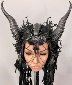 + + + Nemesis + + + colour design: black, silver size: all-size (variable - elastic band) The majestic headpiece is adorned with horns, black feathers, jewelry, bizarre branches, chains, a skull and jawbones. Ribbons, chains and braided pieces of textile take part in this fantastic headdress. The horn is not natural and the headdress is light, very easy to fix and comfortable to wear. You don't like a hat and the only thing you have to do is to adjust the width of the broad and soft elastic band in the neck. The "Maskenzauber" headdress will be delivered on a polystyrene head. + + + + + + + All the "Maskenzauber" headdresses are unique and were created with passion and love for details. I create these extraordinary pieces of jewelry in the atelier for "Maskenzauber & Erlebenskunst" in Berl Adjustable Gothic Costume Accessories For Fantasy Events, Gothic Horned Masks For Fantasy Events, Gothic Masks And Prosthetics For Cosplay With Adjustable Fit, Gothic Adjustable Costume Accessories For Alternative Fashion, Gothic Adjustable Masks And Prosthetics For Costume, Black Mystical Crown Headpiece, Fantasy Masks And Prosthetics For Costume Party, Adjustable Fantasy Masks And Prosthetics For Events, Black Masks And Prosthetics For Cosplay Carnival