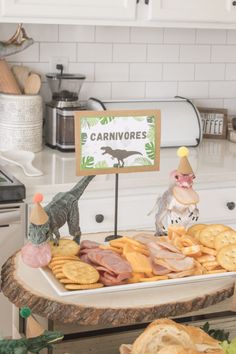 a tray with crackers, cheeses and other food on it in a kitchen