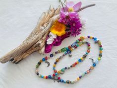 "This cheerful long floral stretchy necklace features 86 glass beads, most of them millefiori, and some small gemstones like, turquoise, jade, agate, cat's eye, howlite, serpentine, 52 silver tone bead dividers and 8 charms, including a lady bug silver charm.  It is 28 inches long and weights  2.5oz. Millefiori  ( Italian) is a glasswork technique which produces distinctive decorative patterns on glassware.  The term millefiori is a combination of the Italian words \"mille' (thousand) and \"fior Spiritual Multicolor Long Necklace, Hand-strung Glass Bohemian Beaded Necklaces, Hand-strung Bohemian Glass Beaded Necklaces, Bohemian Hand-strung Glass Beaded Necklaces, Bohemian Glass Necklaces For Festivals, Adjustable Multicolor Spiritual Long Necklace, Spiritual Multicolor Long Necklace With Gemstone Beads, Bohemian Glass Long Necklace For Gift, Bohemian Glass Long Necklace Gift