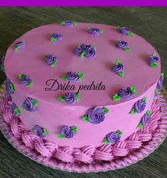 a pink and purple cake with roses on it