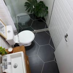 a bathroom with black and white tile flooring, a toilet and sink in it