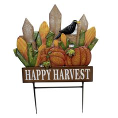 a happy harvest sign with a bird sitting on top of it