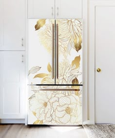 a white refrigerator with gold flowers painted on the front and side doors in a kitchen