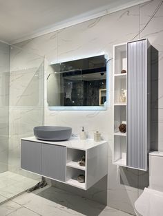 a bathroom with a sink, toilet and mirror in it's corner area next to a shower stall