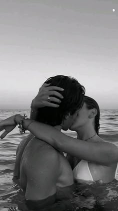 two people in the water kissing each other