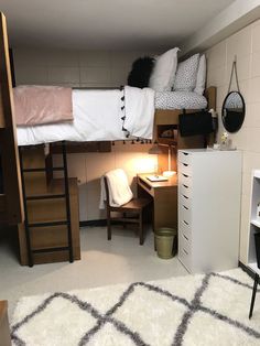 a bedroom with bunk beds and desks in the corner, next to a white rug