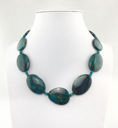 "If you like stunningly beautiful gemstone jewelry that makes a statement then you will love this Chrysocolla necklace with its bold and big oval free form nuggets along with the accents of the Green Chrome Diopside and the Turquoise rondelles that gives this handcrafted piece its powerful presence. It's a \"piece de resistance\" that will transform any ensemble from \"meh\" to \"marvelous\"! The big stones are so smooth and comforting to touch and wear....this is a \"one of a kind\" necklace... Elegant Green Turquoise Necklace In Chrysocolla, Elegant Green Chrysocolla Turquoise Necklace, Elegant Green Turquoise Chrysocolla Necklace, Elegant Turquoise Chrysocolla Necklace, Oval Chrysocolla Necklace With Natural Stones, Elegant Handmade Turquoise Chrysocolla Necklace, Elegant Oval Chrysocolla Necklace, Oval Turquoise Natural Stone Necklaces, Oval Turquoise Necklaces With Natural Stones