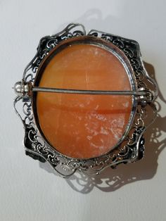 "This Victorian Sterling Silver Cameo Brooch features a Pinkish Shell in an oval shaped octagonal frame, hand carved with a Lady Facing Right. The base metal has intricate Silver metal work with elegant flowers on both sides and bottom side frames. The brooch has an early safety catch and secure. It has the hallmark \"STERLING\" across the inner rim. When you put the brooch up to the light it is transparent. This brooch makes a excellent Christmas Gift or Mother's Day Gift. Will arrive in a gift Ornate Oval Brooch For Formal Occasions, Silver Oval Brooches For Wedding, Ornate Oval Brooches For Formal Occasions, Oval Wedding Brooches With Intricate Design, Oval Brooches With Intricate Design For Wedding, Silver Oval Wedding Brooches, Oval Brooch With Intricate Design As A Gift, Engraved Oval Brooches For Wedding, Ornate Antique Silver Brooches For Formal Occasions